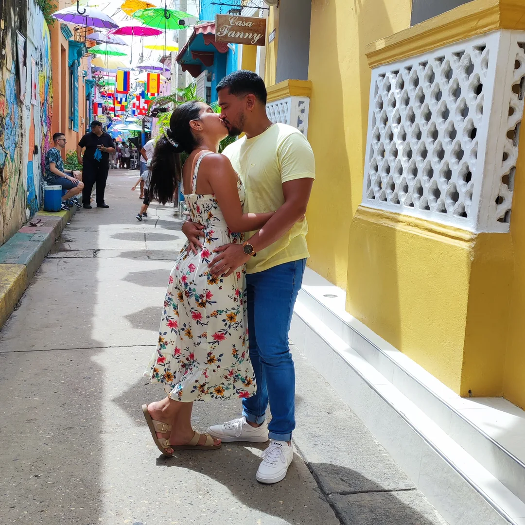 Eric y Lulys recorriendo una calle colorida.